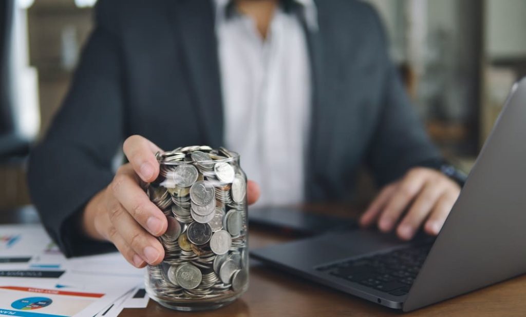 Business Mann mit Glas voll Geld Energie sparen im Unternehmen
