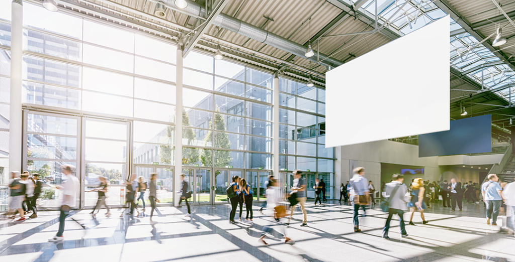 Besucher gehen durch eine Messehalle