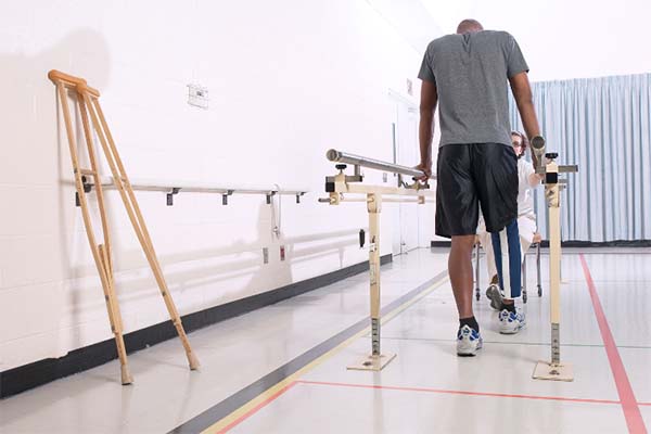 Mann geht mit Prothese unter Beleuchtung für Rehabilitationszentrum