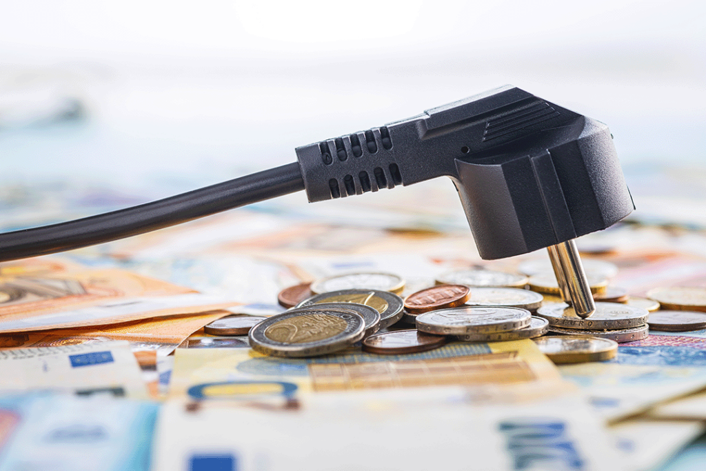 Elektro Stecker liegt auf Geldscheinen und Münzen
