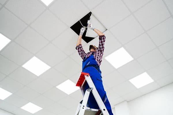 Mann installiert LED Beleuchtung im Unternehmen