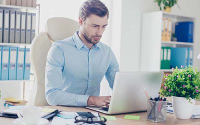 Mann arbeitet an Laptop in gut beleuchtetem Zimmer