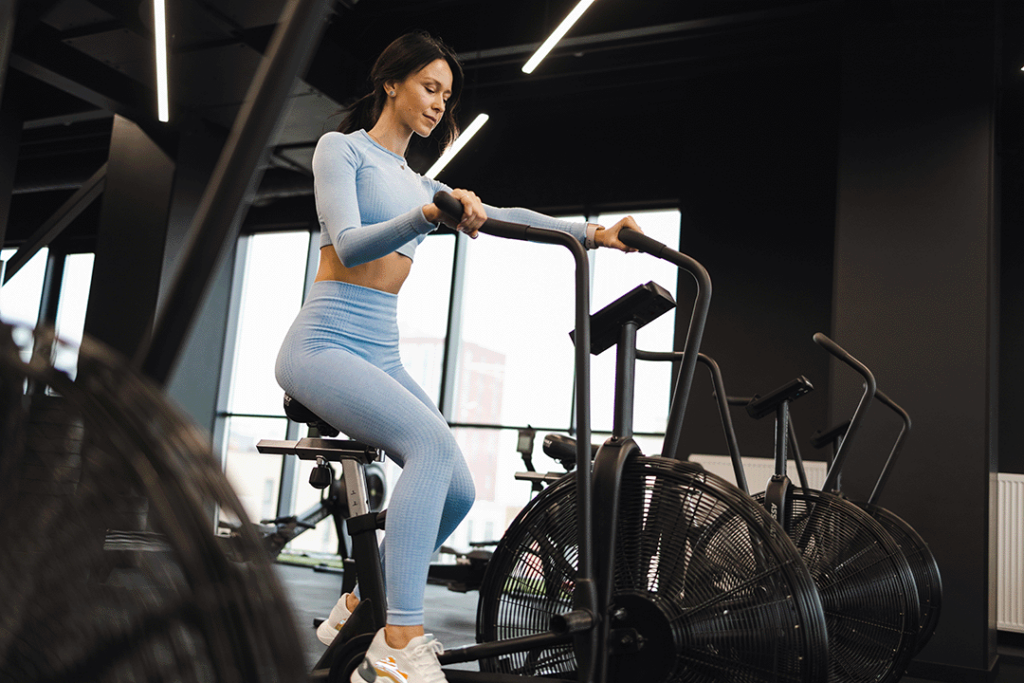 Frau beim Fitnesstraining auf einem Rad